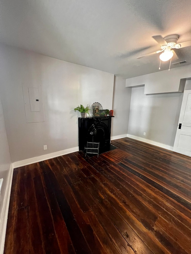 interior space featuring electric panel, dark hardwood / wood-style floors, and ceiling fan