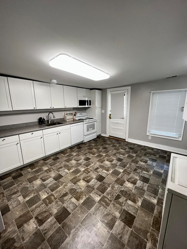 kitchen featuring white appliances, white cabinetry, and sink