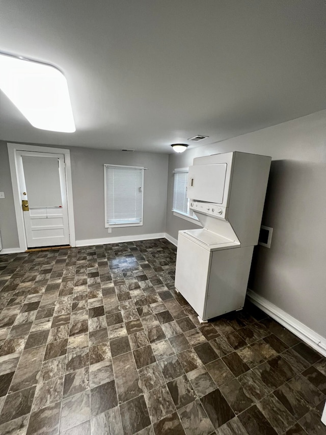 washroom featuring stacked washer / dryer