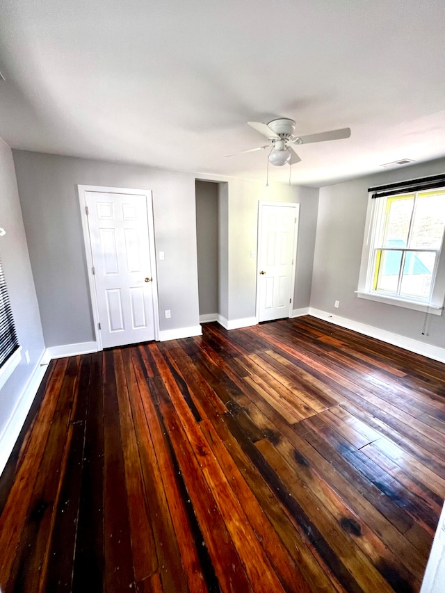 unfurnished bedroom featuring dark wood-type flooring and ceiling fan