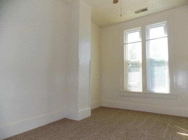 carpeted spare room with ceiling fan