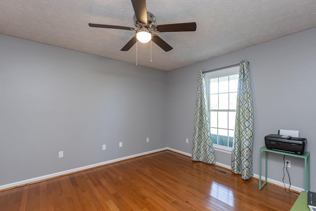 unfurnished room with hardwood / wood-style flooring, ceiling fan, and a textured ceiling