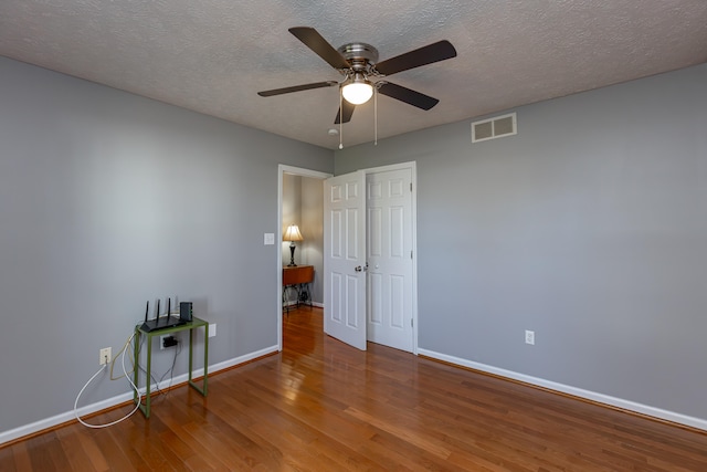 unfurnished room with hardwood / wood-style floors, a textured ceiling, and ceiling fan