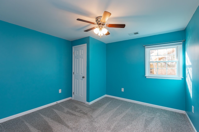 carpeted spare room with ceiling fan