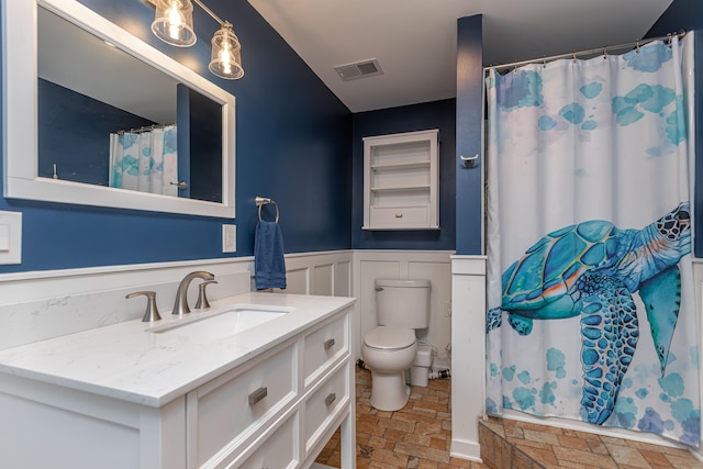 bathroom with curtained shower, vanity, and toilet