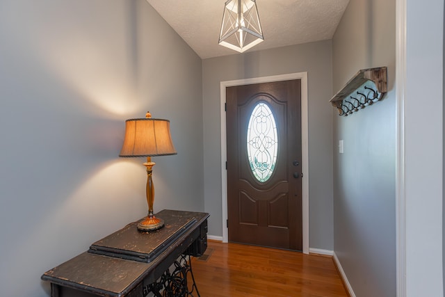 entrance foyer with wood-type flooring and a textured ceiling