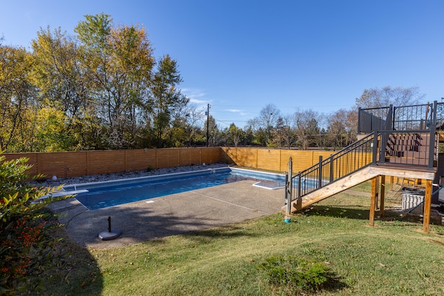 view of swimming pool featuring a diving board and a yard