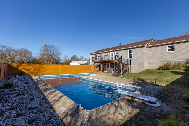 view of pool featuring a patio area, a deck, and a diving board