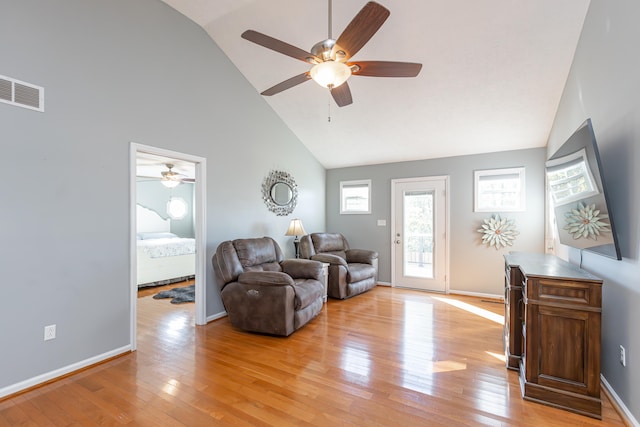 living room featuring light wood-type flooring, ceiling fan, and high vaulted ceiling