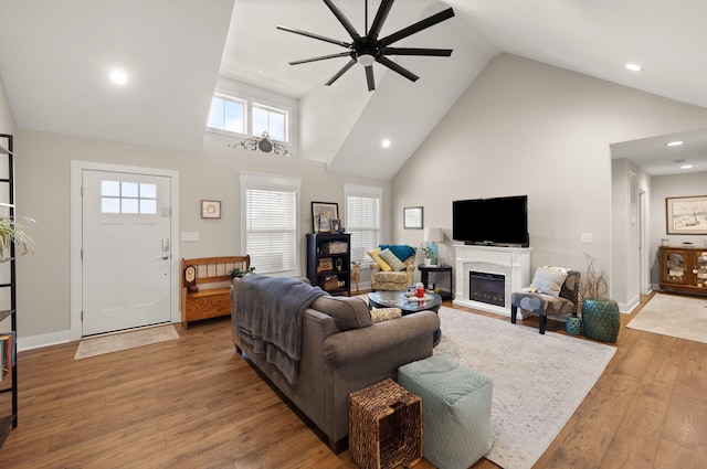 living room with hardwood / wood-style flooring, ceiling fan, plenty of natural light, and high vaulted ceiling