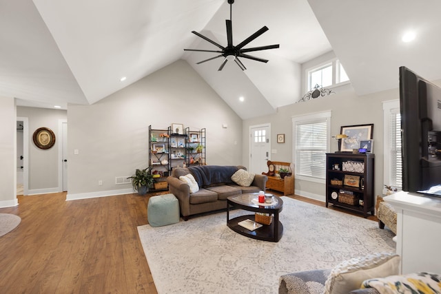 living room with ceiling fan, wood-type flooring, and high vaulted ceiling