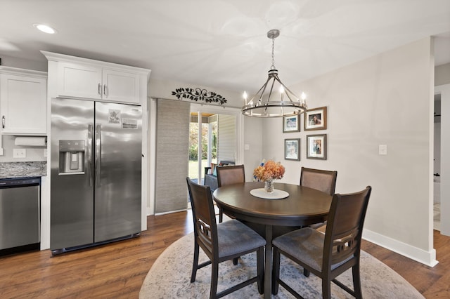 dining area featuring dark hardwood / wood-style floors and a chandelier