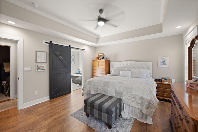 bedroom with ornamental molding, a barn door, ceiling fan, and wood-type flooring