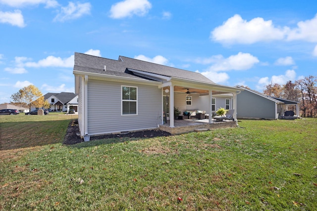 rear view of house with ceiling fan, a lawn, and a patio area