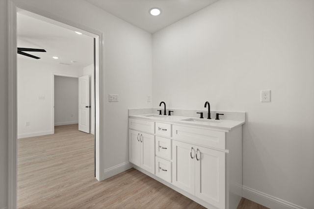 bathroom featuring wood-type flooring, ceiling fan, and vanity