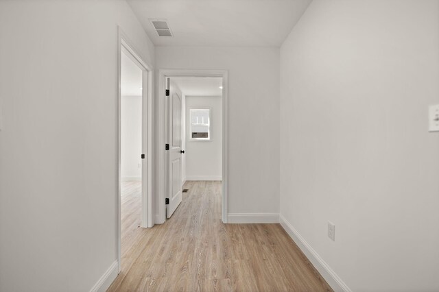 corridor with light hardwood / wood-style floors