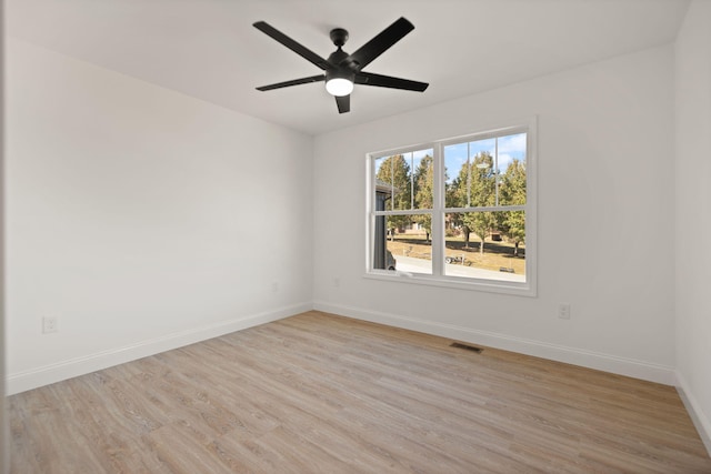 empty room with ceiling fan and light hardwood / wood-style flooring