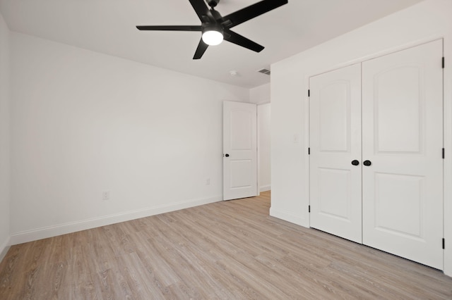 unfurnished bedroom with a closet, light wood-type flooring, and ceiling fan