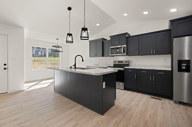 kitchen featuring stainless steel appliances, sink, an island with sink, lofted ceiling, and pendant lighting