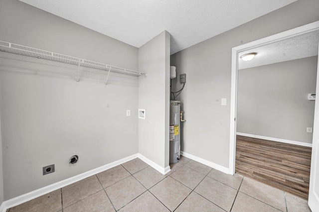 washroom with light hardwood / wood-style floors, water heater, a textured ceiling, and hookup for an electric dryer