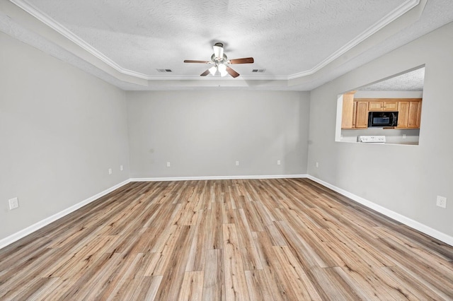 spare room with a textured ceiling, light hardwood / wood-style flooring, and ornamental molding