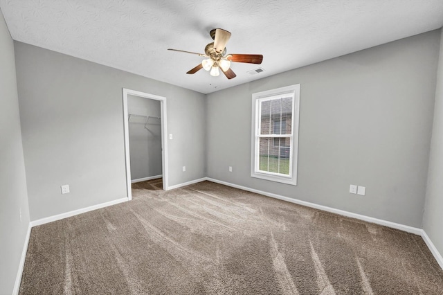 unfurnished bedroom with a closet, a textured ceiling, carpet flooring, and ceiling fan