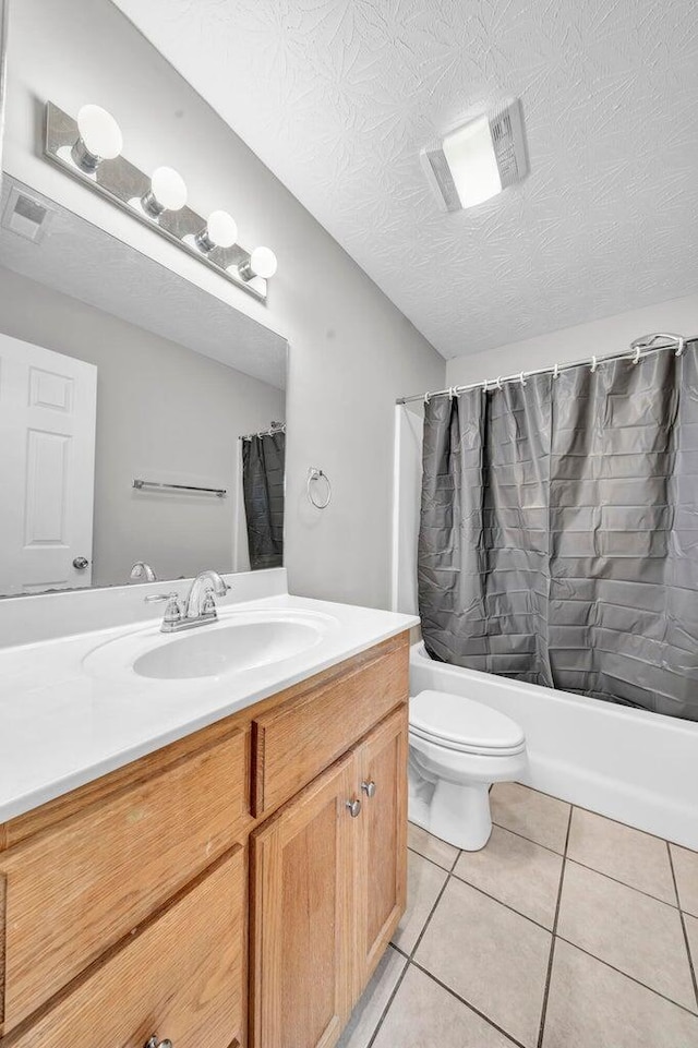 full bathroom with toilet, tile patterned floors, a textured ceiling, vanity, and shower / tub combo with curtain