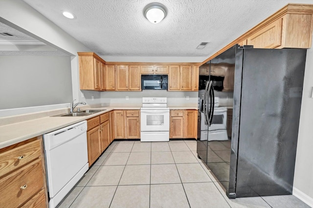 kitchen featuring a textured ceiling, black appliances, sink, and light tile patterned floors