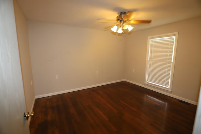 empty room featuring dark wood-type flooring and ceiling fan