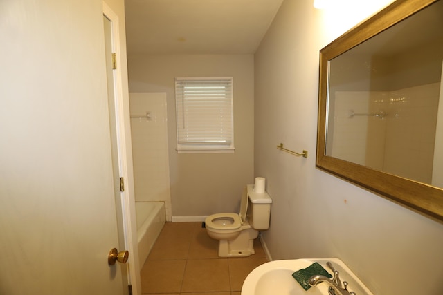 bathroom featuring tiled shower / bath combo, tile patterned floors, and toilet