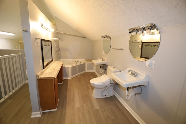 bathroom featuring lofted ceiling, hardwood / wood-style flooring, a textured ceiling, a tub to relax in, and toilet