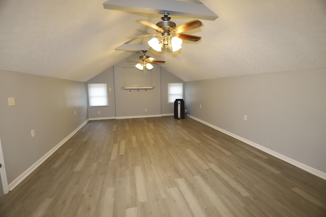 bonus room featuring ceiling fan, lofted ceiling, hardwood / wood-style floors, and a textured ceiling