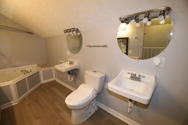 bathroom with lofted ceiling, toilet, sink, a textured ceiling, and hardwood / wood-style floors