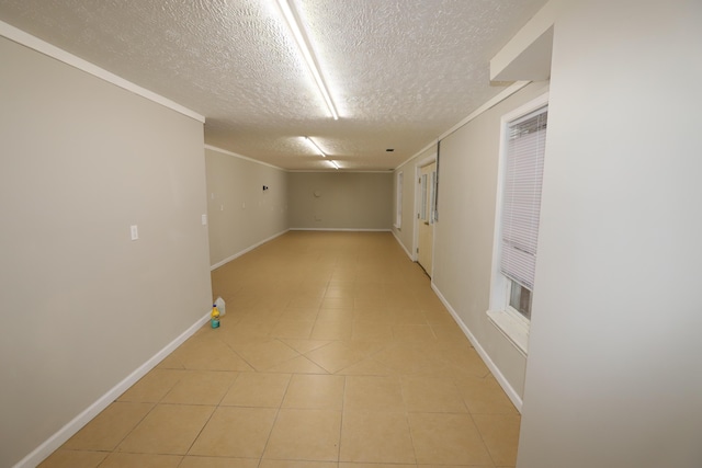 corridor with ornamental molding and a textured ceiling