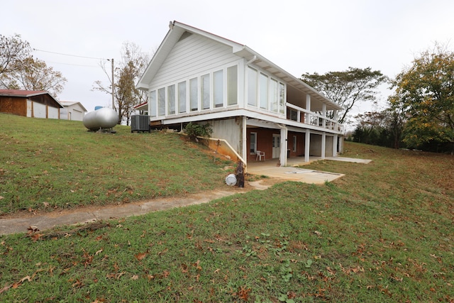 view of side of home with a wooden deck, a lawn, a patio, and central air condition unit