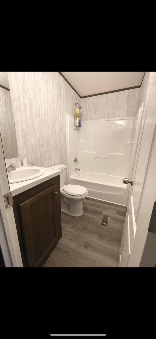 full bathroom featuring toilet, washtub / shower combination, vanity, and hardwood / wood-style flooring