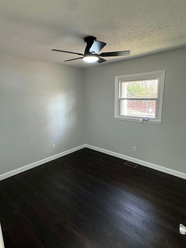 unfurnished room with dark wood-type flooring, ceiling fan, and a textured ceiling