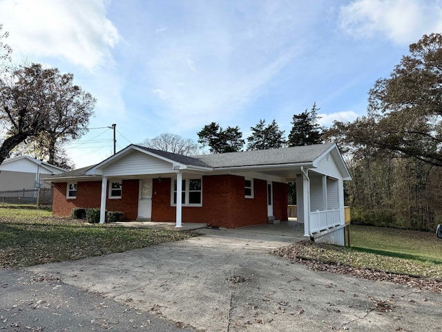 ranch-style house featuring a front lawn and a carport