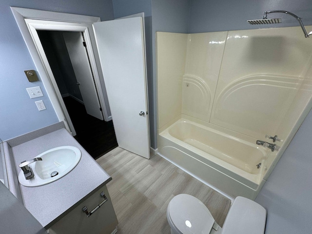 full bathroom featuring toilet, hardwood / wood-style floors, vanity, and shower / bathing tub combination