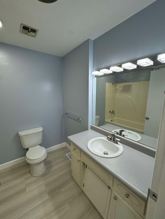 full bathroom featuring toilet, washtub / shower combination, vanity, and hardwood / wood-style flooring