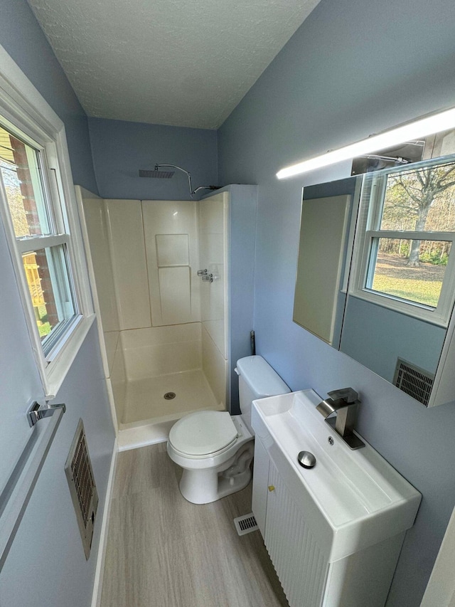 bathroom with a shower, hardwood / wood-style flooring, and plenty of natural light