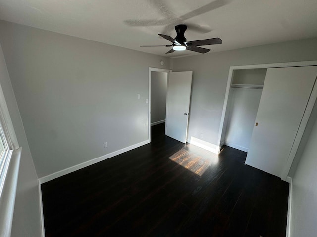 unfurnished bedroom featuring dark wood-type flooring, a closet, and ceiling fan