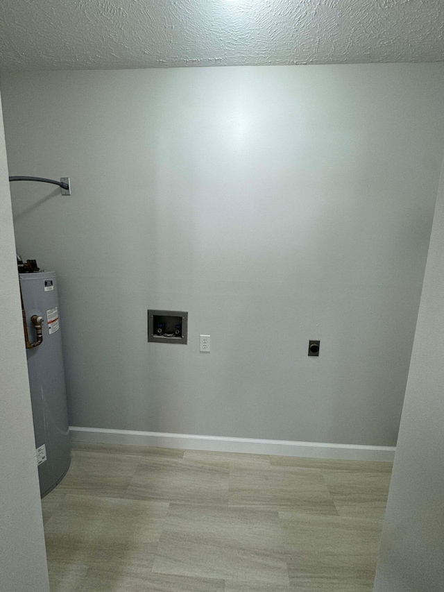 washroom featuring hookup for an electric dryer, water heater, a textured ceiling, washer hookup, and light wood-type flooring