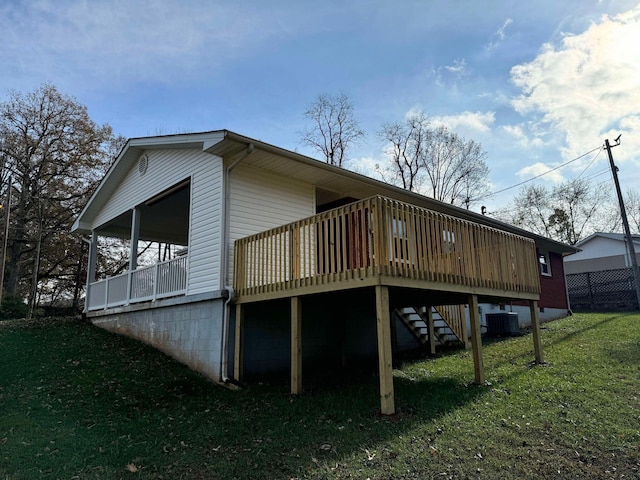 back of property with central AC unit, a lawn, and a deck