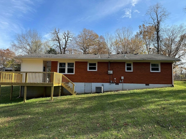 rear view of property with central AC unit, a wooden deck, and a yard