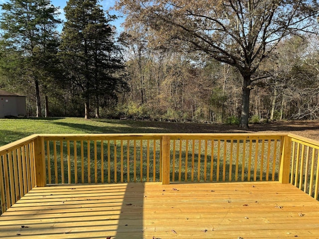 wooden terrace featuring a storage unit and a yard