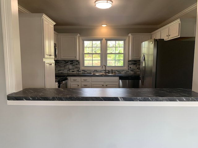 kitchen featuring kitchen peninsula, appliances with stainless steel finishes, decorative backsplash, and white cabinets