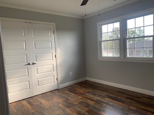 spare room featuring dark wood-type flooring, ceiling fan, and ornamental molding