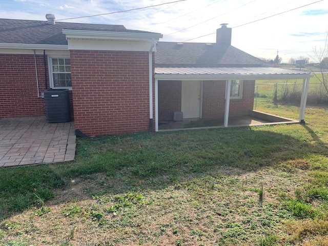 rear view of property featuring a yard, a patio, and cooling unit