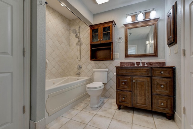 full bathroom with vanity, tiled shower / bath, tile patterned flooring, toilet, and tile walls